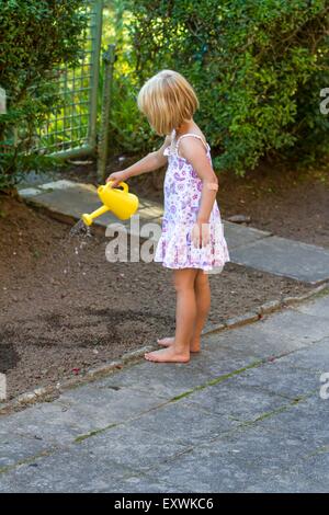 Mädchen Bewässerung von Pflanzen im Garten Stockfoto