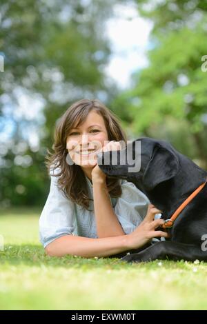 Frau mit einem schwarzen Labrador auf einer Wiese, Bayern, Deutschland, Europa Stockfoto