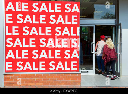 Pfauen hält einen Verkauf zu speichern, wie zwei junge Frauen innen England UK gehen Stockfoto