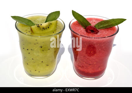 Gläser aus Kiwi und Himbeersaft mit Früchten und frischen Blätter an der Spitze Stockfoto