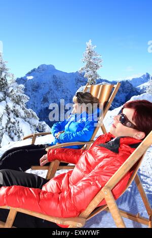 Zwei Frauen in liege im Schnee, Tegelberg, Ammergauer Alpen, Allgäu, Bayern, Deutschland, Europa Stockfoto