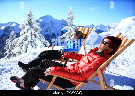 Zwei Frauen in liege im Schnee, Tegelberg, Ammergauer Alpen, Allgäu, Bayern, Deutschland, Europa Stockfoto