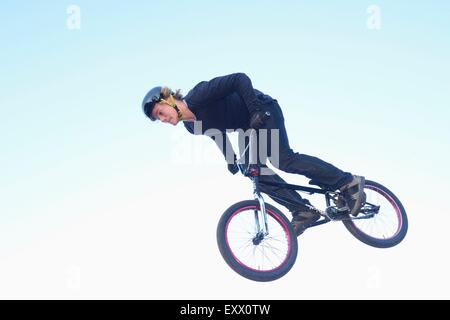 Teenager mit seinem bmx-Rad in der Luft springen Stockfoto