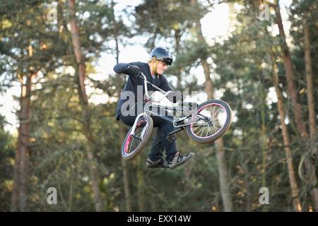 Teenager mit seinem bmx-Rad in der Luft springen Stockfoto