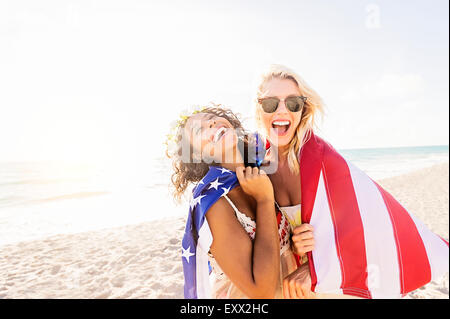 Freundinnen am Strand mit amerikanischen Flagge Stockfoto