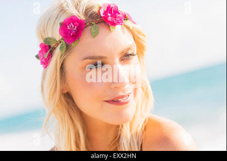 Junge Frau lächelnd am Strand Stockfoto