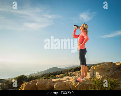 Frau im Sportswear-Trinkwasser Stockfoto