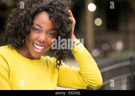 Lächelnde Frau mit Hand im Haar Stockfoto