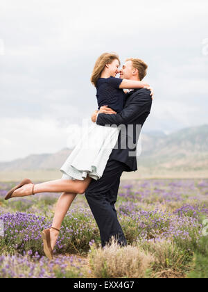 Brautpaar in Lavendelfeld umarmen Stockfoto