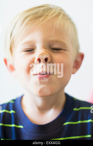 Junge (2-3) lustiges Gesicht hinter Fenster Stockfoto