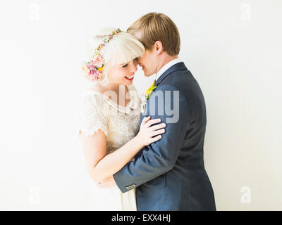 Lächelnd, frisch vermählte Paar umarmt Stockfoto