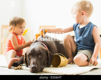 Kinder (2-3) spielen mit Hund Stockfoto