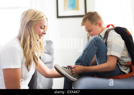 Mutter hilft Sohn Bindung Schuhe (6-7) Stockfoto
