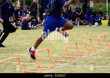 Das Hürden-Rennen an einer Grundschule Sporttag. Stockfoto