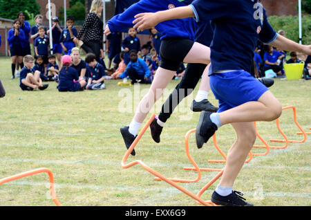 Das Hürden-Rennen an einer Grundschule Sporttag. Stockfoto
