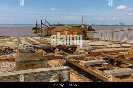 Stillgelegten Werft mit verfallenen Eisen Schiffe und rostigen Seilwinde flankiert von Schlammbänke Humber Mündung. Stockfoto