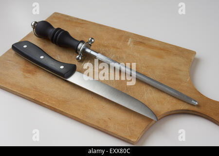 Messer mit Messerschleifer auf Holzbrett Stockfoto