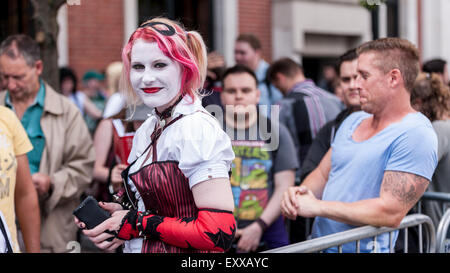 London, UK. 17. Juli 2015. Fans, darunter dieses Mädchen verkleidet als Harley Quin von Batman, versammeln sich vor Olympia in Kensington für den Eröffnungstag der London Film & Comic Con, eine Konvention für Liebhaber von Film, Fernsehen und Comics. Viele Teilnehmer haben die Möglichkeit, ihre auf Bildschirm-Helden während der dreitägigen Veranstaltung durch live-Auftritte von Hollywood Filmstars zu treffen. Bildnachweis: Stephen Chung/Alamy Live-Nachrichten Stockfoto