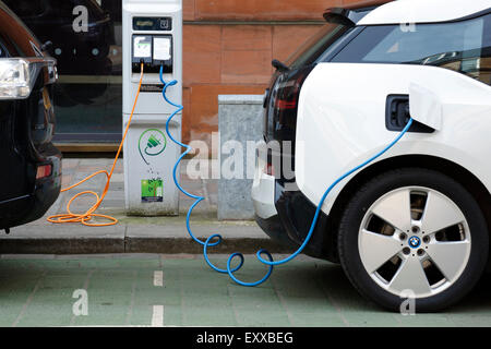 Zwei Elektroautos laden auf einer Stadtstraße, UK Stockfoto