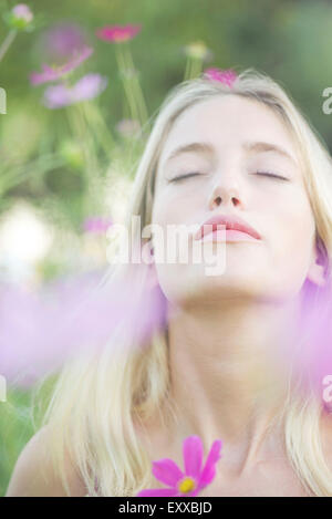 Frau von der süßen Fragrence von blühenden Blumen überwältigt Stockfoto