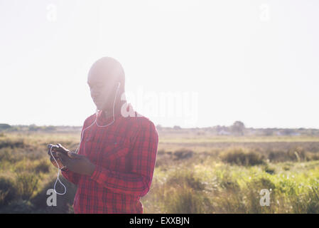 Musikhören mit Kopfhörer im freien Mann Stockfoto