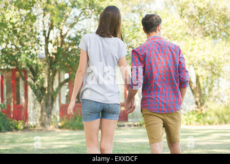 Paar zu Fuß und Hand in Hand im Freien, Rückansicht Stockfoto