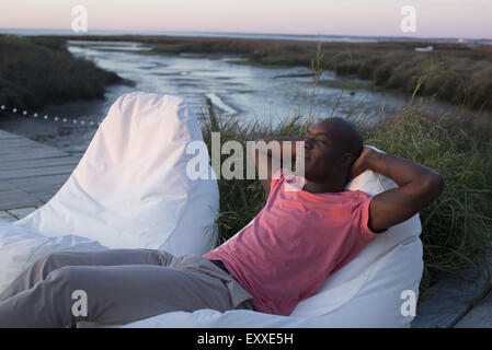 Mann am Rand des Wassers entspannend Stockfoto