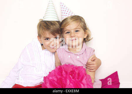 Bruder und Schwester tragen Partyhüte, Porträt Stockfoto