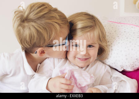 Junge kleine Schwester Wange küssen Stockfoto