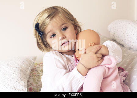 Kleine Mädchen umarmt Puppe Stockfoto