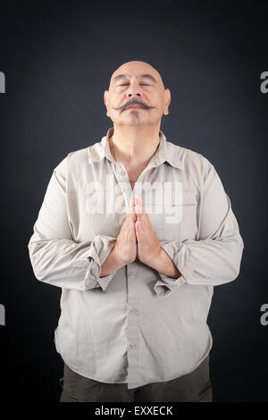 Hübscher Mann dabei verschiedene Ausdrücke in verschiedenen Arten von Kleidung: Gebet Stockfoto
