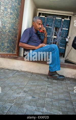 Havanna, Kuba - 16. Mai 2011: Kubanische Telefon Techniker sitzt im Inneren eine Anschlussdose Prüfung Verbindungen auf der Straße. Stockfoto