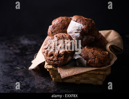 Schokoladen-Muffins mit Nüssen in Korb, auf dunklem Hintergrund, selektiven Fokus Stockfoto