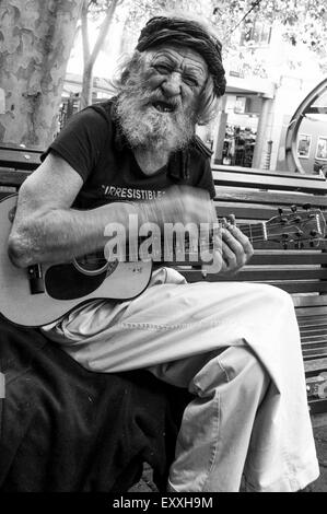 Ein bärtiger Mann spielt Gitarre auf einer Bank in Newcastle, Australien.    Bildnachweis: Euan Cherry Stockfoto