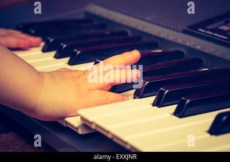 Nahaufnahme der Tastatur Synthetizer. Abstrakte Hintergrundmusik mit Händen der Kinder spielen auf der Tastatur. Stockfoto