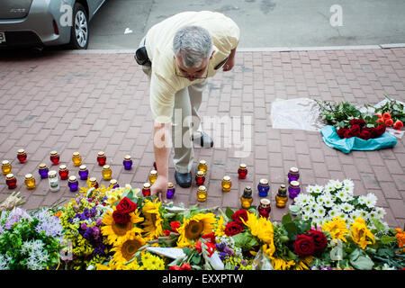 Kiew, Ukraine - 17. Juli 2015: ein Mann legt Blumen in Gedenken an die Opfer der Malaysia Airlines MH17 Flugzeugunglück in der Ostukraine, vor der niederländischen Botschaft in Kiew. Das Datum markiert ein Jahr, nachdem das Flugzeug über die Ukraine abgeschossen wurde, 298 Menschen getötet Stockfoto