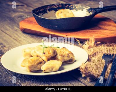 Vintage Foto von frittierten Teigtaschen mit Zwiebel in einer Pfanne erhitzen. Stockfoto