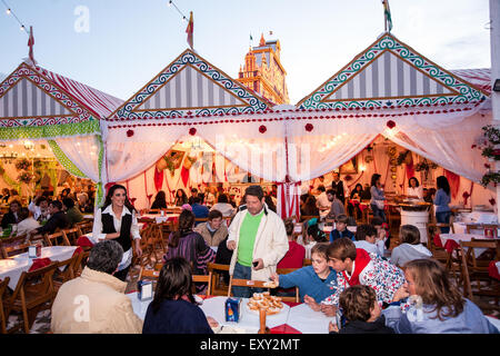 Einheimische in traditionellen Sevilla Kleid mit Snacks von Donuts und Schokoladengetränke Chocolat con Churros in Sevilla, Andalusien, Stockfoto