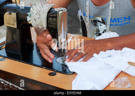 Nahaufnahme der Hände des Mannes, während er in eine Nähmaschine, Catania Straßenmarkt, Catania, Sizilien, Italien Betrieb ist Stockfoto