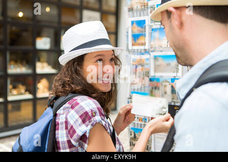 Ansicht von jungen glücklichen paar Auswahl Postkarten in den Ferien Stockfoto