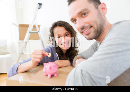 Blick auf ein junges Paar, Geld zu sparen in ein Sparschwein Stockfoto