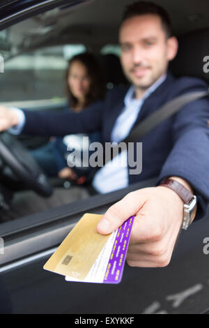 Blick auf ein paar in seinem Auto an einer Mautstelle Zahlen Stockfoto