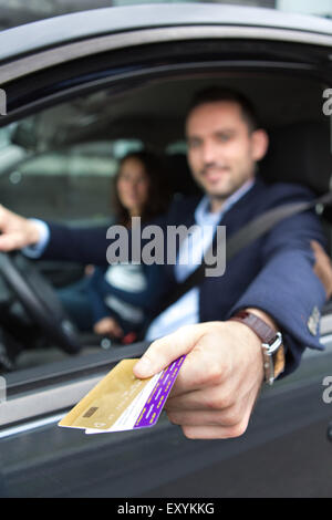 Blick auf ein paar in seinem Auto an einer Mautstelle Zahlen Stockfoto