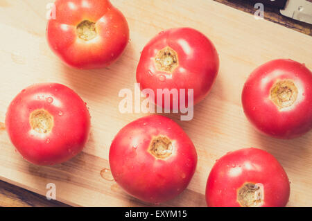 Ein Cutting Board nassen Tomaten und Messer Draufsicht für Hintergrund. Pastell-filter Stockfoto