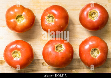 Frische nasse Tomaten auf der Board-Oberseite für Hintergrund anzeigen Stockfoto