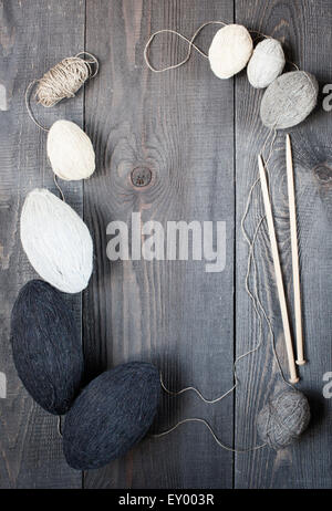 Stränge und Stricknadeln auf dem dunklen Vintage Tisch Stockfoto