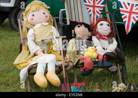 Stoffpuppen, die sitzen in einem Liegestuhl auf einem Marktstand zum Verkauf Stockfoto