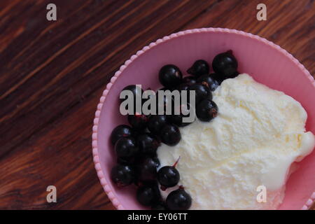 auf einem Holzbrett süßes Dessert Eis mit schwarzen Johannisbeeren Stockfoto