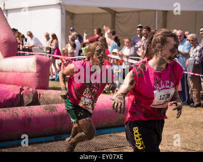 Portsmouth, UK. 18. Juli 2015. Zwei Damen Kopf in Richtung Ziellinie bedeckt im Schlamm während der Race For Life - ziemlich matschig. Das Rennen um Leben ziemlich schlammig Veranstaltung richtet sich an Frauen nur und besteht aus einem 5K Schlamm bedeckt-Hindernis-Parcours Credit: Simon Evans/Alamy Live News Stockfoto