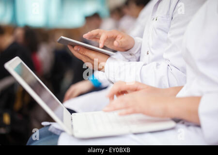 Medizinstudenten mit Pad und Laptops im auditorium Stockfoto